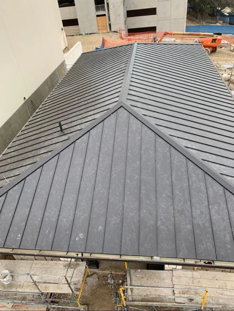 Commercial metal roof construction with crane equipment in Haslet