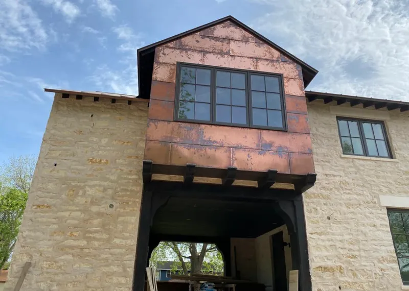 Copper metal panel facade on a stone building for Skylight Installation in Haslet